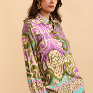 Woman wearing a colorful patterned outfit on a beige background
