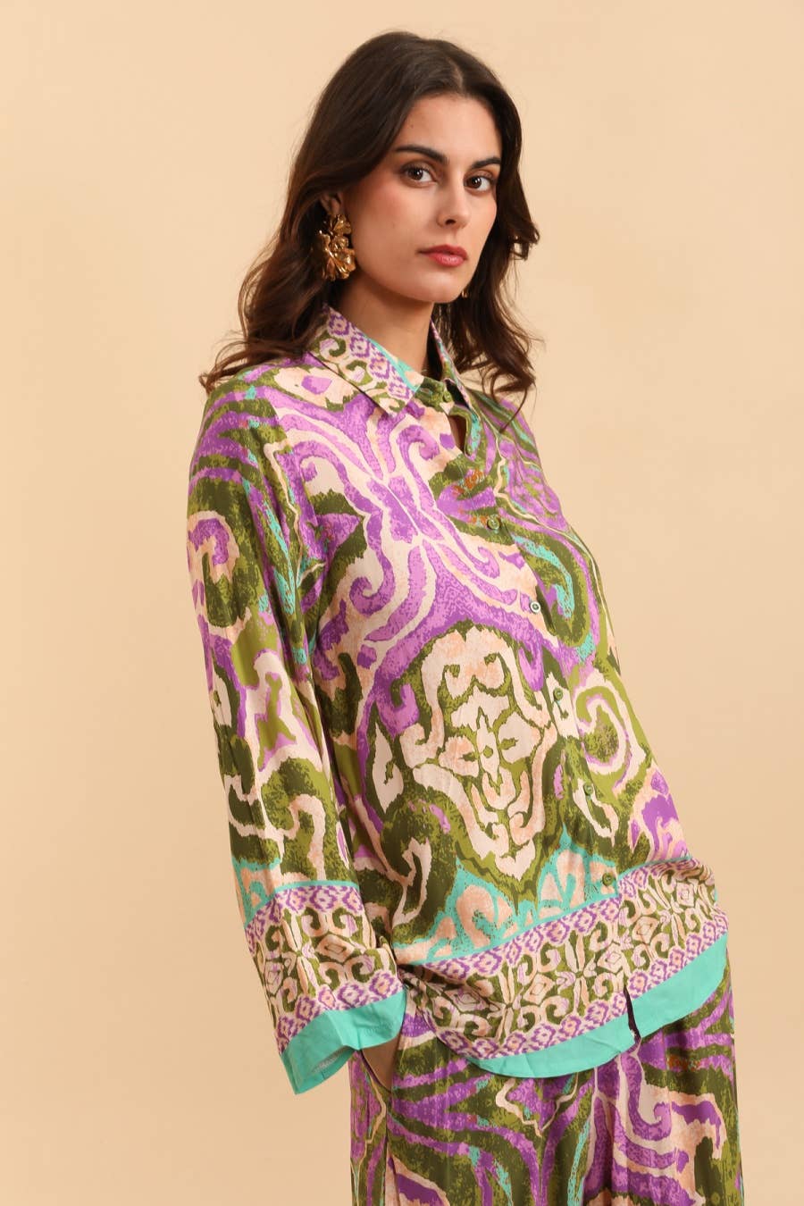 Woman wearing a colorful patterned outfit on a beige background